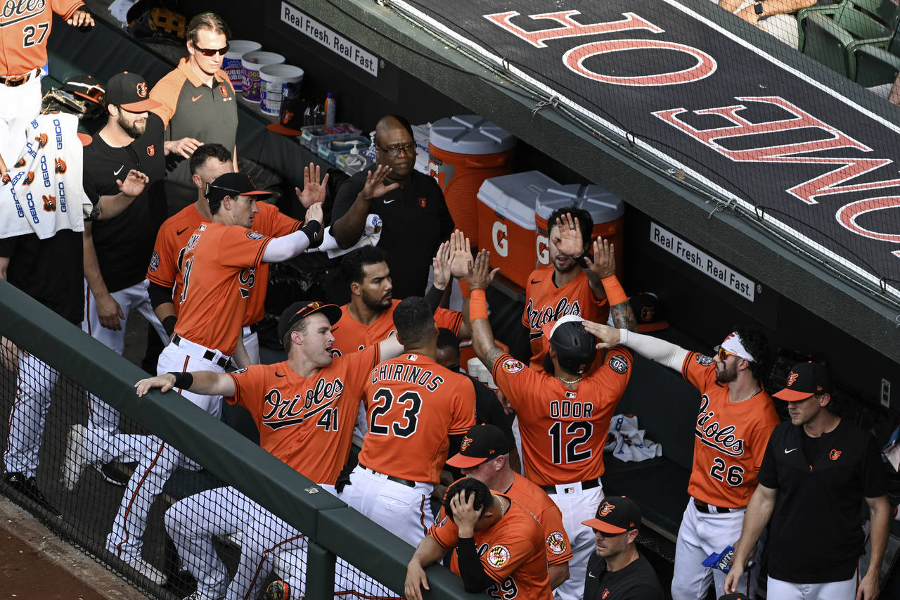 Baltimore Orioles' Rougned Odor (12) is greeted by teammates after scoring a run on a single by Jor...
