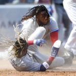 
              Toronto Blue Jays Vladimir Guerrero Jr., top, collides with teammate Raimel Tapia (15) after being tagged out against the New York Yankees at home plate, during the fifth inning of a baseball game Saturday, Aug. 20, 2022, in New York. Tapia scored on the play  (AP Photo/Noah K. Murray)
            