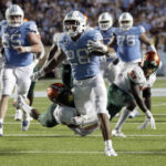 
              North Carolina's Omarion Hampton (28) tries to break a tackle-attempt by Florida A&M's Kendall Bohler (3) during the first half of an NCAA college football game in Chapel Hill, N.C., Saturday, Aug. 27, 2022. (AP Photo/Chris Seward)
            