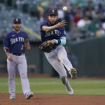 
              Seattle Mariners shortstop J.P. Crawford, middle, throws out Oakland Athletics' David MacKinnon at first base during the second inning of a baseball game in Oakland, Calif., Friday, Aug. 19, 2022. (AP Photo/Jeff Chiu)
            
