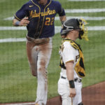 
              Milwaukee Brewers' Christian Yelich (22) scores next to Pittsburgh Pirates catcher Tyler Heineman with one of two runs on a double by Willy Adames during the second inning of a baseball game Wednesday, Aug. 3, 2022, in Pittsburgh. (AP Photo/Keith Srakocic)
            
