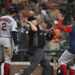 
              Home plate umpire Todd Tichenor, center, throws out Boston Red Sox's Xander Bogaerts, left, who argued a called third strike duirng the fourth inning of the team's baseball game against the Baltimore Orioles, Friday, Aug. 19, 2022, in Baltimore. Red Sox manager Alex Cora, right, was also ejected. (AP Photo/Gail Burton)
            
