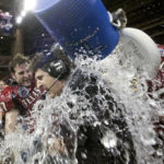 
              FILE - Texas Tech coach Mike Leach, center, is dunked with water by Wes Welker (27), left, and Cody Campbell (64) right during the final minutes against Navy in the Houston Bowl on Dec. 30, 2003 in Houston. Of the top 25 most-prolific passing seasons in major college football history by yards per game, 12 have direct connections to Hal Mumme and Leach — from Kentucky to Houston to Texas Tech to New Mexico State to Washington State. (AP Photo/David J. Phillip, File)
            