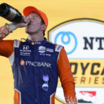 
              Scott Dixon takes a drink of champagne after winning the Music City Grand Prix auto race Sunday, Aug. 7, 2022, in Nashville, Tenn. (AP Photo/Mark Humphrey)
            