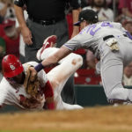 
              St. Louis Cardinals' Lars Nootbaar, left, is tagged out by Colorado Rockies third baseman Ryan McMahon after Nootbaar overran third base during the eighth inning of a baseball game Wednesday, Aug. 17, 2022, in St. Louis. (AP Photo/Jeff Roberson)
            