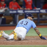 
              Tampa Bay Rays' Harold Ramirez reaches back to score the game-winning run against the Los Angeles Angels during the 11th inning of a baseball game Wednesday, Aug. 24, 2022, in St. Petersburg, Fla. The Rays won 4-3. (AP Photo/Mike Carlson)
            