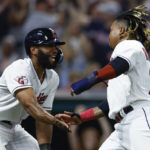 
              Cleveland Guardians' Amed Rosario. left, and Jose Ramirez celebrate after scoring on a single by Andres Gimenez during the seventh inning of a baseball game against the Chicago White Sox, Friday, Aug. 19, 2022, in Cleveland. (AP Photo/Ron Schwane)
            