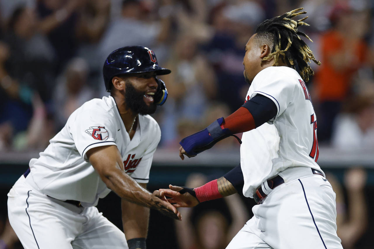 Cleveland Guardians' Amed Rosario. left, and Jose Ramirez celebrate after scoring on a single by An...