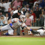 
              New York Mets catcher James McCann, left, attempts to tag Atlanta Braves' Vaughn Grissom at home plate during the seventh inning of a baseball game Thursday, Aug. 18, 2022, in Atlanta. Grissom scored on a double by Michael Harris II. (AP Photo/Brett Davis)
            