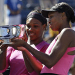 
              FILE - Serena Williams, left, of the United States, and her sister Venus examine the championship trophy after winning the women's doubles championship over Cara Black, of Zimbabwe, and Liezel Huber, of the United States, at the U.S. Open tennis tournament in New York, Monday, Sept. 14, 2009.  Serena and Venus Williams were given a wild-card entry for women's doubles at the U.S. Open on Saturday, Aug. 27, 2022, making it their first tournament as a team in more than four years. (AP Photo/Darron Cummings, File)
            
