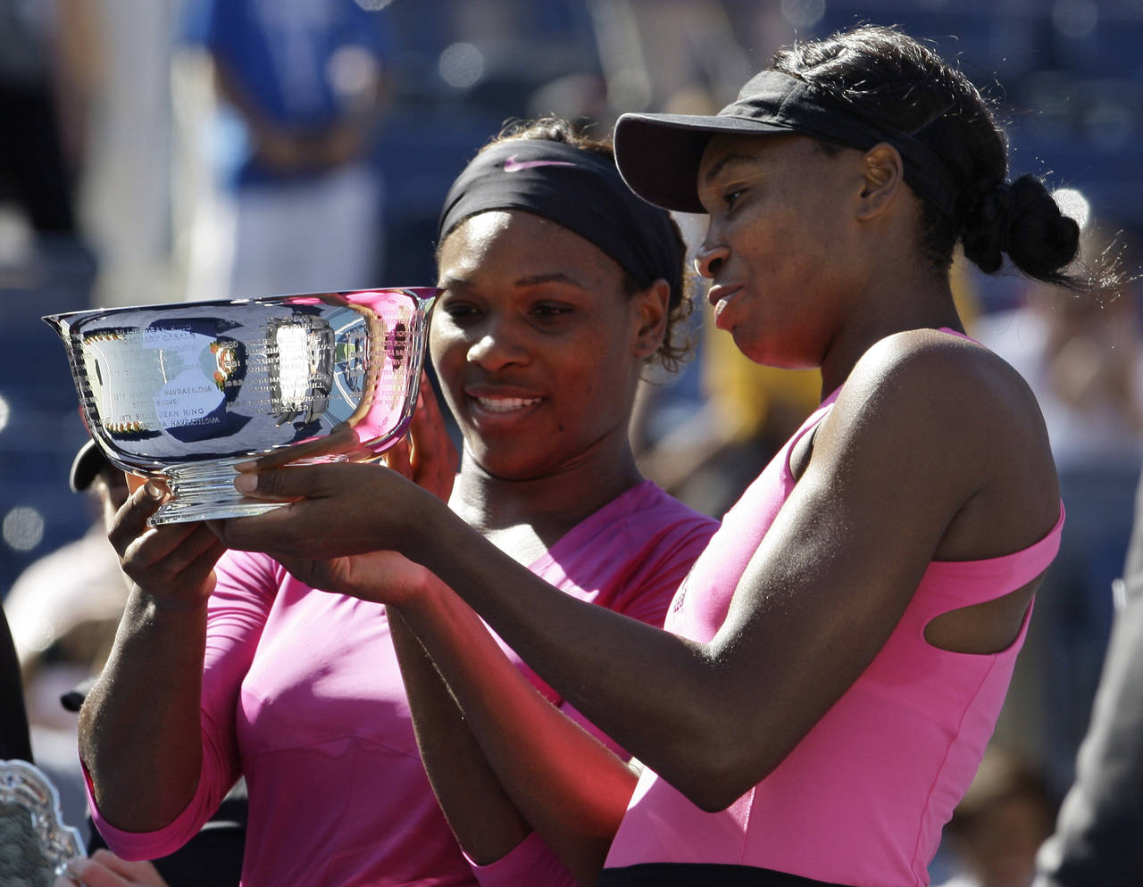 FILE - Serena Williams, left, of the United States, and her sister Venus examine the championship t...