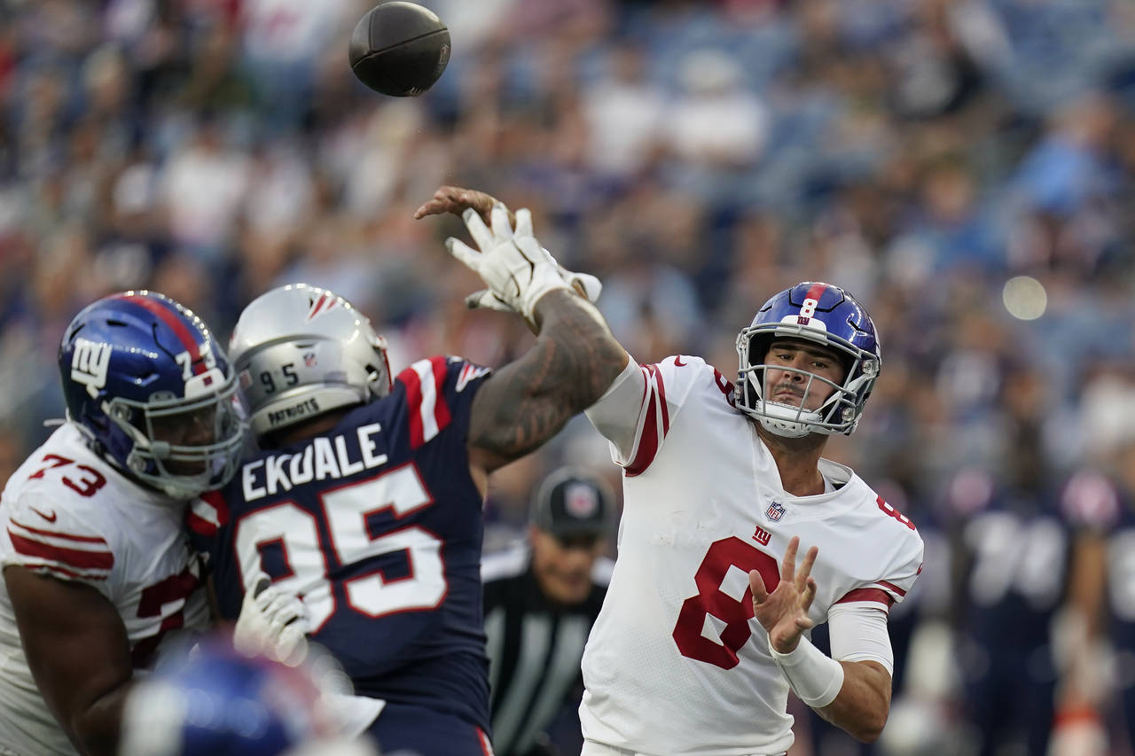 New York Giants quarterback Daniel Jones (8 throws a pass over New England Patriots defensive tackl...