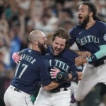 
              Seattle Mariners' Luis Torrens, center, is greeted by teammates Mitch Haniger, left, and J.P. Crawford, right, after Torrens hit a walk-off RBI single to give the Mariners a 1-0 win over the New York Yankees in a 13-inning baseball game, Tuesday, Aug. 9, 2022, in Seattle. (AP Photo/Ted S. Warren)
            