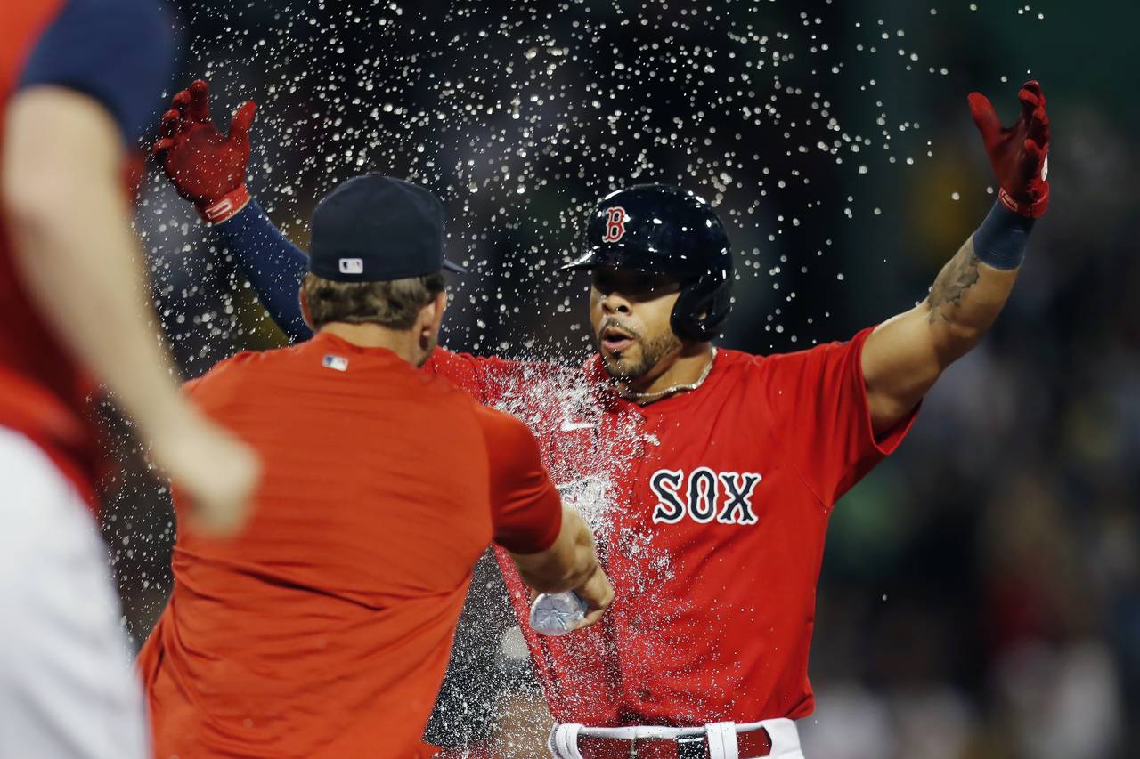 Boston Red Sox's Tommy Pham, right, celebrates after hitting a walkoff RBI-single during the 10th i...
