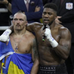 
              Britain's Anthony Joshua, right, speaks to the crowd after losing to Ukraine's Oleksandr Usyk in their world heavyweight title fight at King Abdullah Sports City in Jeddah, Saudi Arabia, Sunday, Aug. 21, 2022. (AP Photo/Hassan Ammar)
            