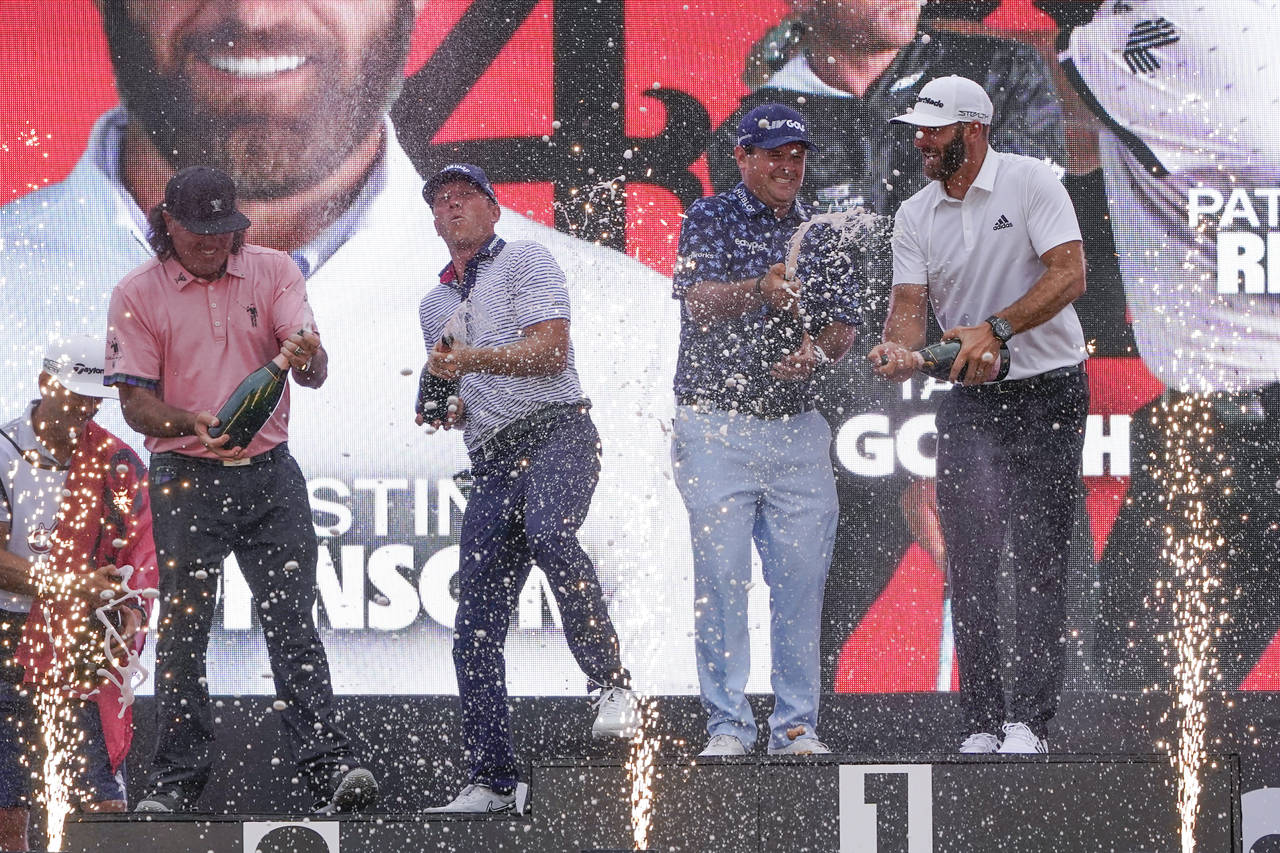 The "4 Aces" team celebrates with champagne after winning the team competition during a ceremony af...