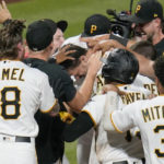 
              Pittsburgh Pirates' Bryan Reynolds, center, is surrounded by teammates at home plate as he celebrates a game-ending home run against the Milwaukee Brewers in the ninth inning of a baseball game Wednesday, Aug. 3, 2022, in Pittsburgh. The Pirates won 8-7. (AP Photo/Keith Srakocic)
            