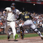 
              San Francisco Giants' Joc Pederson, left, scores on Wilmer Flores' RBI double past Pittsburgh Pirates catcher Jason Delay during the fourth inning of a baseball game in San Francisco, Sunday, Aug. 14, 2022. (AP Photo/Jeff Chiu)
            