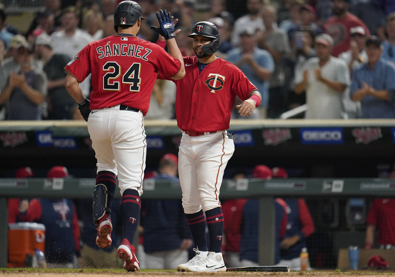Minnesota Twins' Gary Sanchez, left, celebrates with Gilberto Celestino, right, after hitting a two...