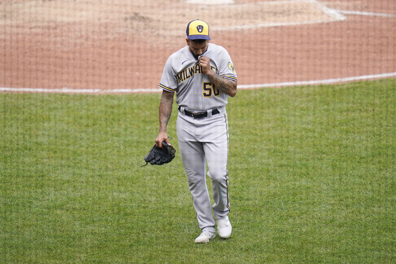 Milwaukee Brewers reliever Matt Bush leaves the field after throwing a wild pitch with the bases lo...