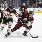 
              Canada's Elliot Desnoyers (19) and Latvia's Ralfs Bergmanis (16) battle for the puck during the second period of an IIHF junior world hockey championships game Wednesday, Aug. 10, 2022, in Edmonton, Alberta. (Jason Franson/The Canadian Press)
            