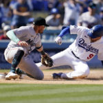 
              Los Angeles Dodgers' Gavin Lux (9) is tagged out at third base by Miami Marlins shortstop Miguel Rojas while trying for a triple during the seventh inning of a baseball game Sunday, Aug. 21, 2022, in Los Angeles. (AP Photo/Marcio Jose Sanchez)
            