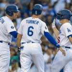 
              Los Angeles Dodgers' Freddie Freeman, left, and Trea Turner, center, congratulate designated hitter Will Smith, after Smith hits a three-run home run against the Miami Marlins during the first inning of a baseball game in Los Angeles, Saturday, Aug. 20, 2022. (AP Photo/Alex Gallardo)
            