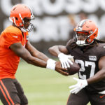
              Cleveland Browns quarterback Deshaun Watson hands off to running back Kareem Hunt (27) during the NFL football team's training camp, Tuesday, Aug. 9, 2022, in Berea, Ohio. (AP Photo/Ron Schwane)
            
