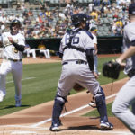 
              Oakland Athletics' Seth Brown (15) runs home to score as New York Yankees catcher Kyle Higashioka, middle, and pitcher Clarke Schmidt watch for the ball during the first inning of a baseball game in Oakland, Calif., Sunday, Aug. 28, 2022. (AP Photo/Jeff Chiu)
            