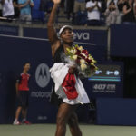 
              Serena Williams, of the United States, leaves the court carrying flowers and waving to fans after her loss to Belinda Bencic, of Switzerland, during the National Bank Open tennis tournament Wednesday, Aug. 10, 2022, in Toronto. (Nathan Denette/The Canadian Press via AP)
            