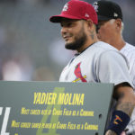 
              St. Louis Cardinals catcher Yadier Molina holds one of his gifts given by the Colorado Rockies to mark his retirement before the first inning of a baseball game Tuesday, Aug. 9, 2022, in Denver. (AP Photo/David Zalubowski)
            