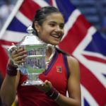 
              FILE - Emma Raducanu, of Britain, holds up the U.S. Open championship trophy after defeating Leylah Fernandez, of Canada, during the women's singles final of the U.S. Open tennis championships on Sept. 11, 2021, in New York. Raducanu was 18 and ranked just 150th when she won last year's U.S. Open. Her title defense will begin Tuesday, Aug. 30, 2022, in a match against Alize Cornet, of France. (AP Photo/Elise Amendola, File)
            