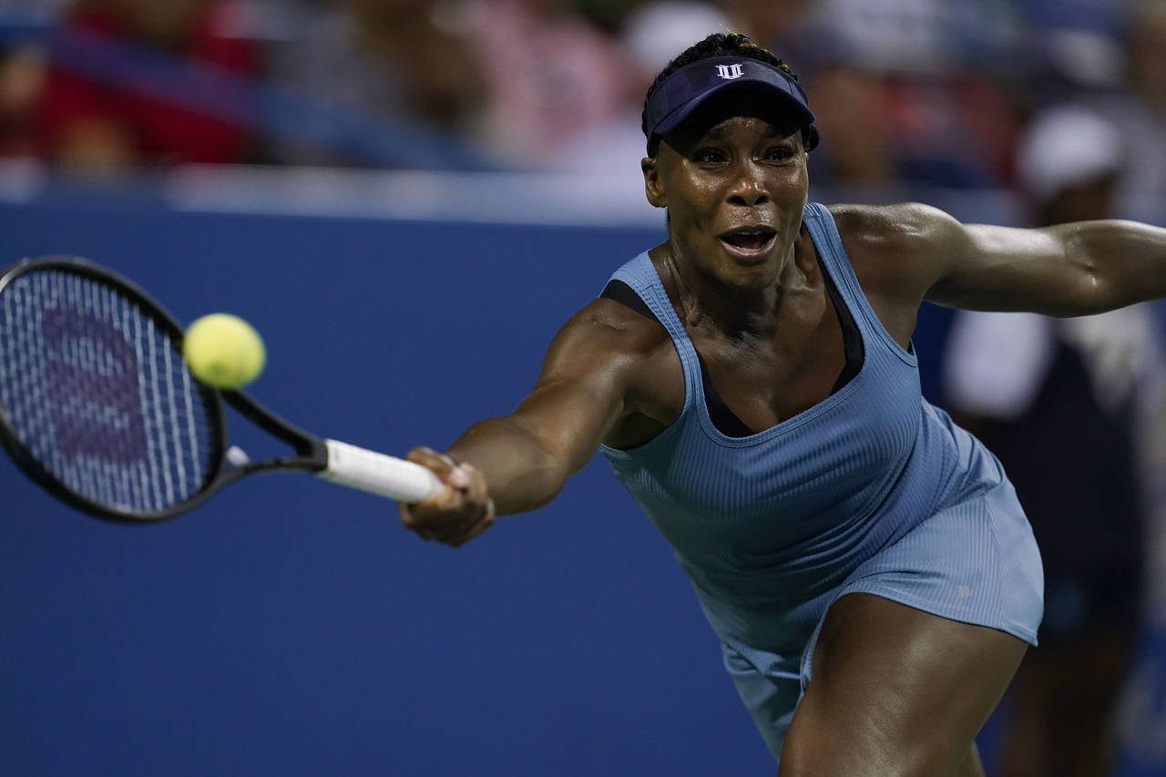 Venus Williams, of the United States, returns during a first-round match against Rebecca Marino, of...