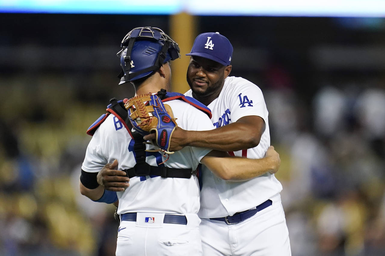 Los Angeles Dodgers catcher Austin Barnes (15) and relief pitcher Hanser Alberto (17) hug after a 1...