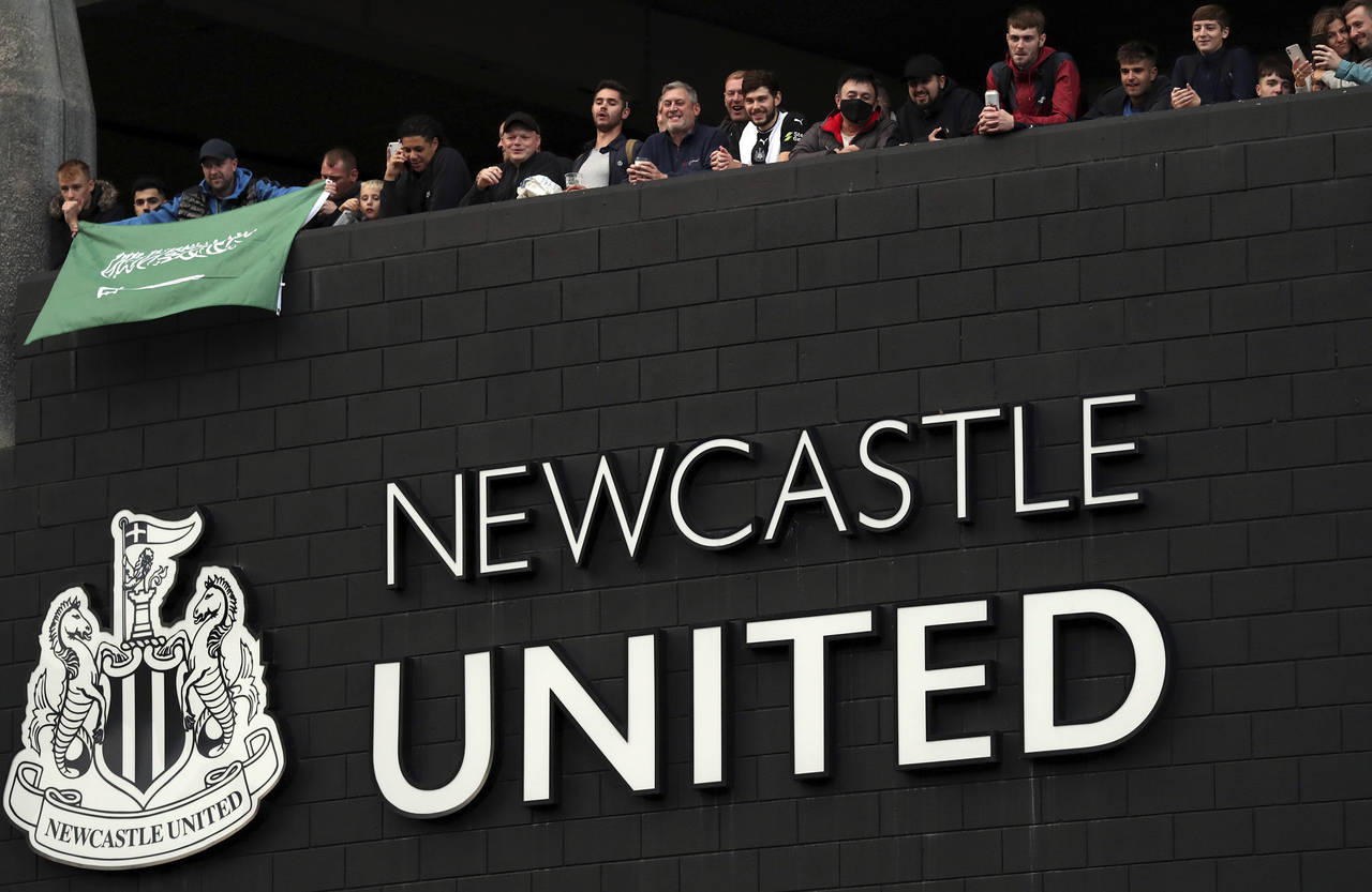 FILE - Newcastle United supporters celebrate outside St. James' Park in Newcastle Upon Tyne, Englan...