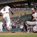 
              Minnesota Twins' Luis Arraez scores past San Francisco Giants catcher Joey Bart during the ninth inning of a baseball game Saturday, Aug. 27, 2022, in Minneapolis. (AP Photo/Abbie Parr)
            