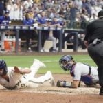 
              Milwaukee Brewers' Tyrone Taylor slides safely past Los Angeles Dodgers catcher Austin Barnes during the eighth inning of a baseball game Wednesday, Aug. 17, 2022, in Milwaukee. Taylor scored on a hit by Christian Yelich. (AP Photo/Morry Gash)
            