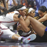 
              Dallas Wings forward Isabelle Harrison, right, battles against Connecticut Sun center Brionna Jones, left, and forward DiJonai Carrington (21) for the ball during Game 1 of a WNBA basketball first-round playoff series Thursday, Aug. 18, 2022, in Uncasville, Conn. (Sean D. Elliot/The Day via AP)
            