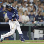 
              Seattle Mariners' Eugenio Suarez hits a solo home run on a pitch from Cleveland Guardians starter Zach Plesac during the second inning of a baseball game, Saturday, Aug. 27, 2022, in Seattle. (AP Photo/John Froschauer)
            