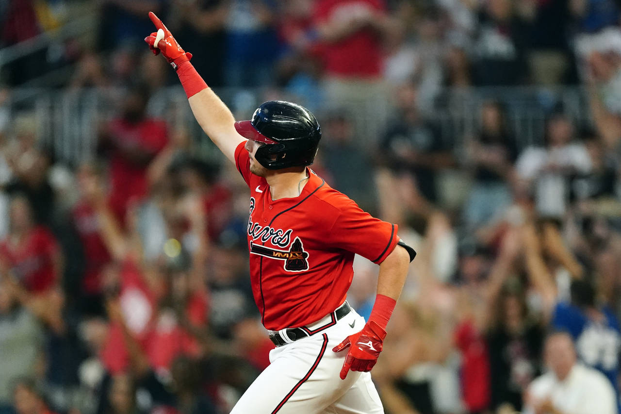 Atlanta Braves' Austin Riley gestures as he runs the bases after hitting a three-run home run in th...