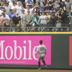 
              New York Yankees right fielder Aaron Judge watches as fans try to catch a two-run home run hit by Seattle Mariners' Carlos Santana during the seventh inning of a baseball game, Wednesday, Aug. 10, 2022, in Seattle. (AP Photo/Ted S. Warren)
            