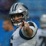 
              Carolina Panthers quarterback Baker Mayfield points in the rain during warms up before an NFL preseason football game against the Buffalo Bills on Friday, Aug. 26, 2022, in Charlotte, N.C. (AP Photo/Jacob Kupferman)
            