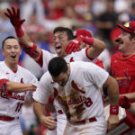 
              St. Louis Cardinals' Lars Nootbaar is congratulated by teammates Tommy Edman (19), Nolan Arenado (28) and Miles Mikolas, right, after hitting a walk-off single to score Arenado during the ninth inning in the first game of a baseball doubleheader against the Chicago Cubs Thursday, Aug. 4, 2022, in St. Louis. (AP Photo/Jeff Roberson)
            
