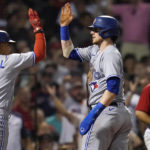 
              Toronto Blue Jays' Danny Jansen celebrates with Santiago Espinal (5) after scoring on a single by Vladimir Guerrero Jr. during the fourth inning of a baseball game, Thursday, Aug. 25, 2022, in Boston. (AP Photo/Charles Krupa)
            