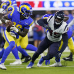 
              Los Angeles Rams quarterback Bryce Perkins, left, is chased by Houston Texans linebacker Ogbonnia Okoronkwo (45) during the second half of a preseason NFL football game Friday, Aug. 19, 2022, in Inglewood, Calif. (AP Photo/Jae C. Hong)
            