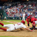 
              Philadelphia Phillies' Rhys Hoskins, left, is tagged out at home by Cincinnati Reds catcher Austin Romine after trying to score on a double by J.T. Realmuto during the seventh inning of a baseball game, Wednesday, Aug. 24, 2022, in Philadelphia. (AP Photo/Matt Slocum)
            
