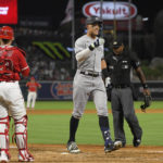 
              New York Yankees' Aaron Judge, center, gestures as he scores after hitting a three-run home run while Los Angeles Angels catcher Max Stassi, left, watches along with home plate umpire Alan Porter during the fourth inning of a baseball game Tuesday, Aug. 30, 2022, in Anaheim, Calif. (AP Photo/Mark J. Terrill)
            