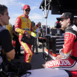 
              Ryan Blaney, right, and Joey Logano, center, talk with a crew member prior to practice and qualifying at Richmond Raceway for Sunday's NASCAR Cup Series auto race Saturday, Aug. 13, 2022, in Richmond, Va. (AP Photo/Steve Helber)
            