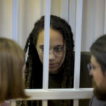 
              WNBA star and two-time Olympic gold medalist Brittney Griner speaks to her lawyers in a courtroom for a hearing, in Khimki just outside Moscow, Russia, Tuesday, Aug. 2, 2022. Since Brittney Griner last appeared in her trial for cannabis possession, the question of her fate expanded from a tiny and cramped courtroom on Moscow's outskirts to the highest level of Russia-US diplomacy. (Evgenia Novozhenina/Pool Photo via AP)
            