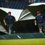 
              Members of the grounds crew pull a tarp over the field during the seventh inning of a baseball game between the Philadelphia Phillies and the Miami Marlins, Tuesday, Aug. 9, 2022, in Philadelphia. (AP Photo/Matt Rourke)
            